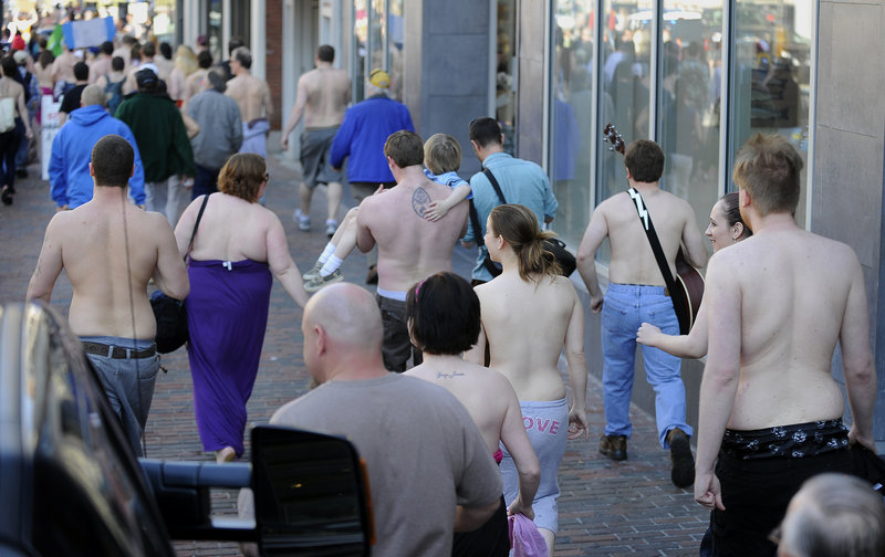 Bare-chested men and women walk together along a Congress Street sidewalk Saturday in Portland as part of an effort to promote equal opportunity public toplessness.