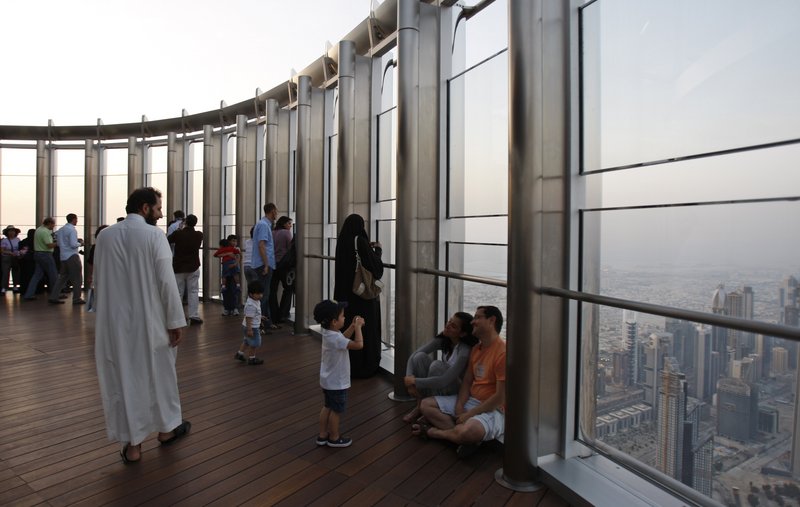 A boy takes a picture of his parents on the 124th-floor observation deck of the world’s tallest skyscraper Sunday in Dubai. The deck was shut in February after an elevator malfunction.