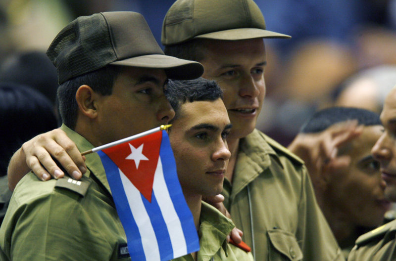 Elian Gonzales, center, poses for a photo at the Young Communist Union congress in Havana. Ten years ago this month, he was removed from the home of relatives in Miami and returned to Cuba.