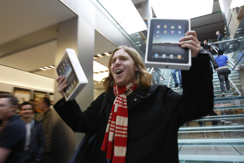 Andres Schobel holds up two iPads as one of the first customers to buy the electronic tablet on the first day of sales at an Apple Store in San Francisco on Saturday. Apple said Monday that it delivered more than 300,000 iPads on its opening day.