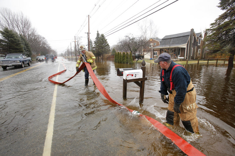 Bill Van Deinse, left, and John Thyng, with the Kennebunk Fire Department, help to pump out yards along Alfred Road in Kennebunk last Wednesday after two days of rain.