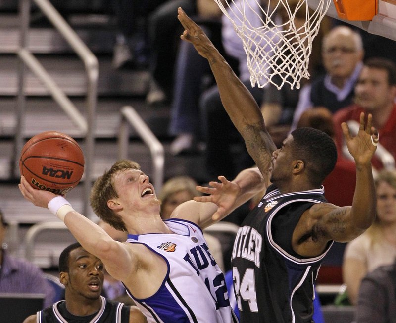 Kyle Singler, left, of Duke faces plenty of pressure from Butler’s Avery Jukes as he tries to put up a shot Monday night in the men’s final at Indianapolis. Singler had 19 points in the Blue Devils’ 61-59 victory.