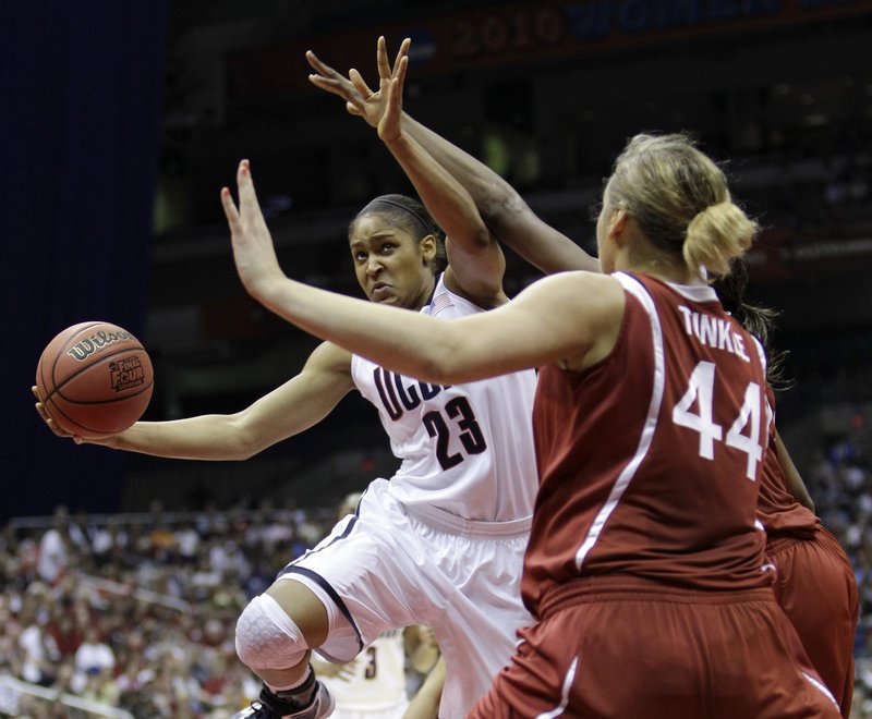 Maya Moore of Connecticut battles her way to the basket as Stanford’s Joslyn Tinkle moves into her path. Moore had 23 points and 11 rebounds and the Huskies came on in the second half to beat the Cardinal 53-47 for the title.