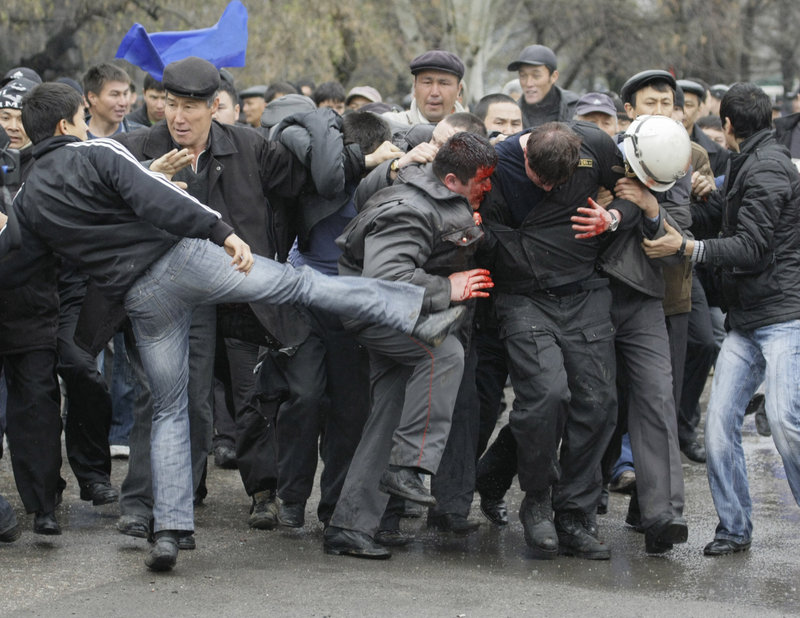 A protester kicks at police Wednesday in Bishkek, Kyrgyzstan. Opposition leaders have called for the closure of a U.S. air base that serves as a key transit point for supplies essential to the war in nearby Afghanistan.