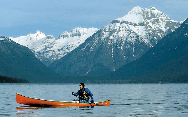 Jon Crandall of Coram, Mont., paddles his canoe across Lake McDonald in Glacier National Park, Mont. Scientists said Wednesday that the park has lost two more of its namesake moving ice fields to climate change, which is shrinking the rivers of ice until they halt.