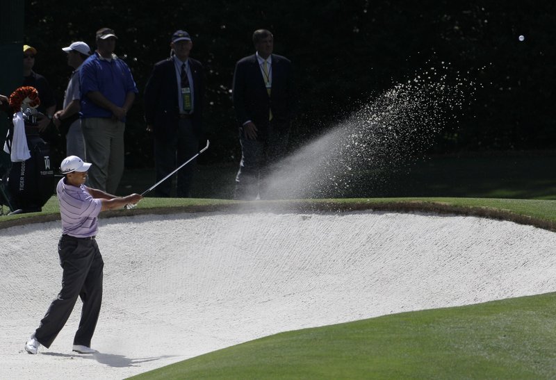 Tiger Woods blasts out of a bunker on the fourth hole, leading to one of his five bogeys in the third round. But Woods scrambled for a 2-under 70 and was tied for third, four strokes behind Lee Westwood.