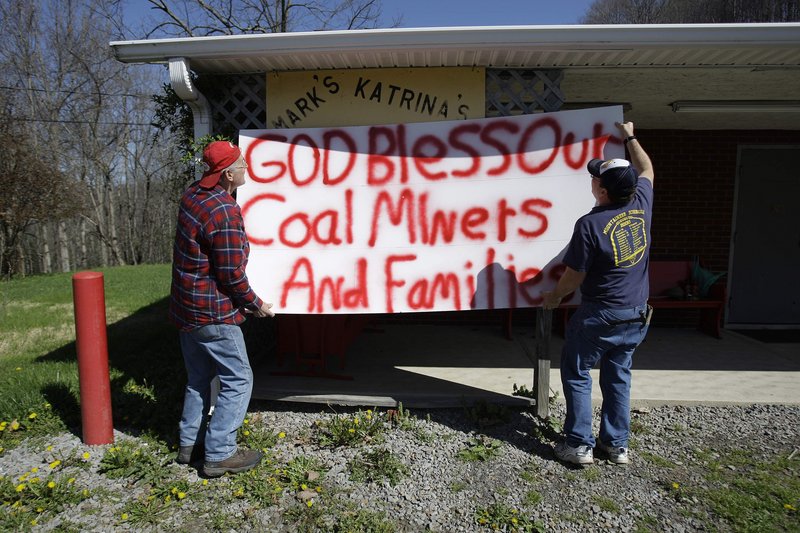Mark Aliff, right, and Johnny Sarrett hang a sign in support of coal miners and their families on the front of Aliff's barber shop in Rock Creek, W.Va., on Saturday. Aliff was barber to many of the 29 miners who were killed in Monday's explosion at Massey Energy Co.s Upper Big Branch mine.