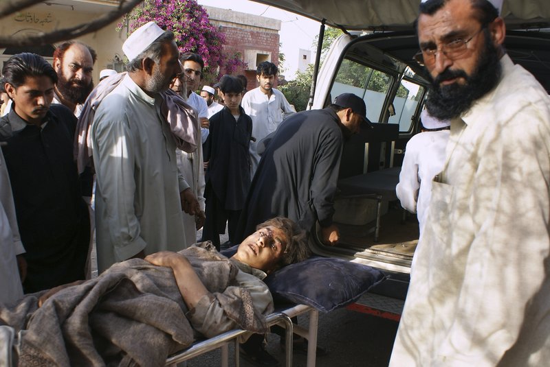 Pakistani tribesmen accompany a boy injured in strikes by Pakistani military jets as he arrives at a hospital on the outskirts of Peshawar on Saturday.