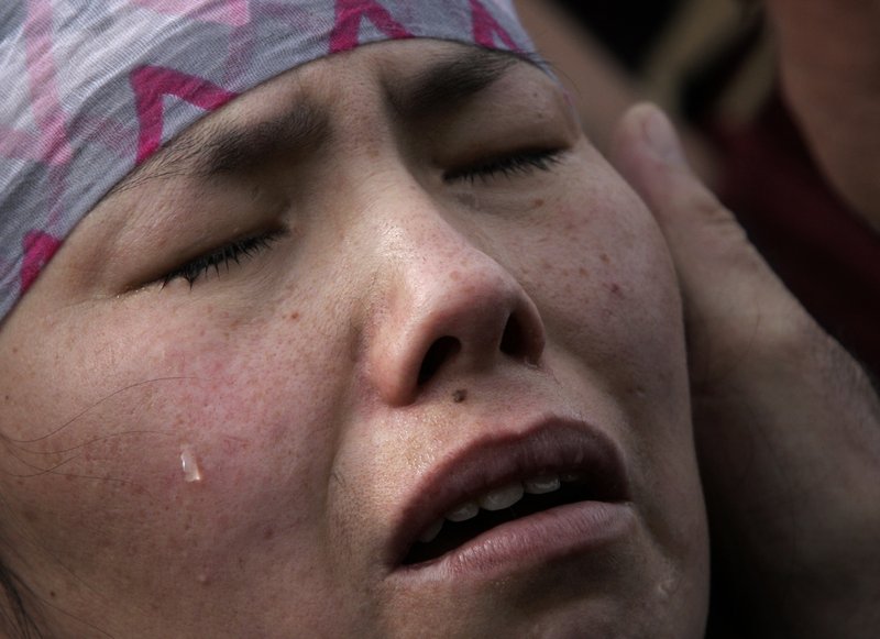 A relative of a victim grieves during a mass funeral at the Ata-Beyit memorial complex on the outskirts of Bishkek, Kyrgyzstan, on Saturday.