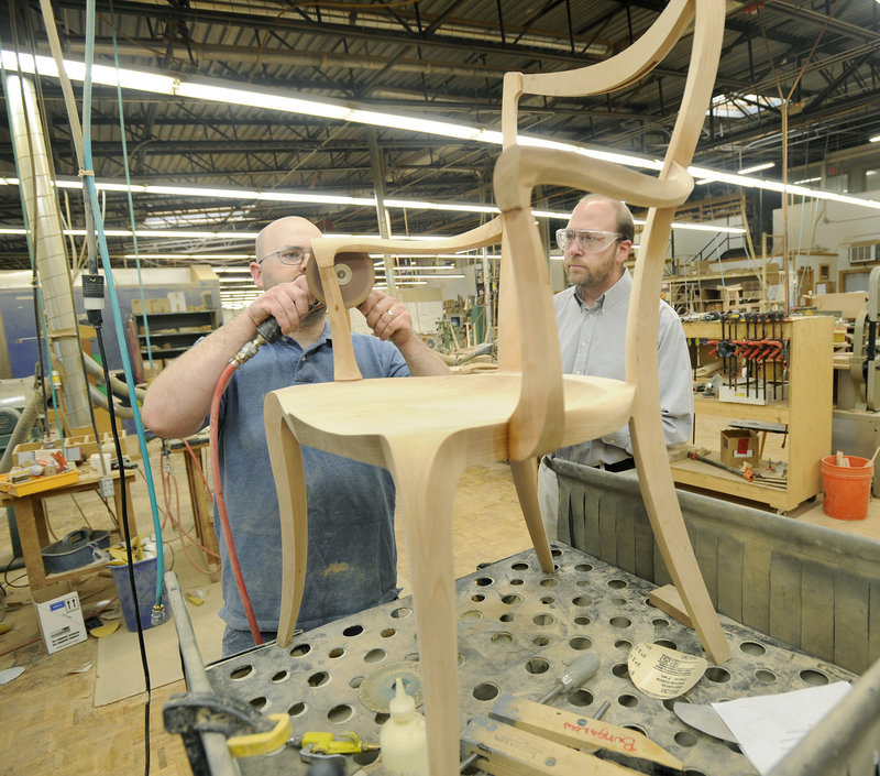 Cabinetmaker George Colby Jr., left, shows reporter Ray Routhier how to sand a chair at Thos. Moser Cabinetmakers. It takes nine to 10 hours to make a chair.