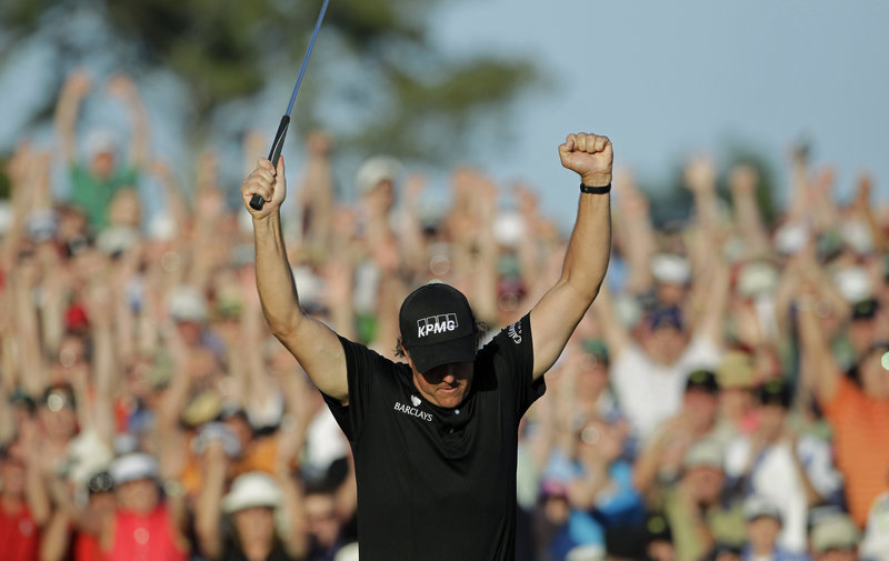 After sinking an 8-foot birdie putt on the final hole Sunday, Phil Mickelson raises his arms in celebration of his three-shot victory in the Masters at Augusta, Ga. Mickelson finished with a 5-under-par 67 to earn his third green jacket and fourth major title overall.