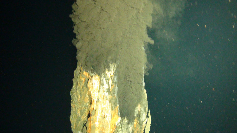 A cloud of smoky water billows from a tower of metal ore at a volcanic vent more than three miles beneath the surface of the Caribbean. Pressure keeps the water from boiling.