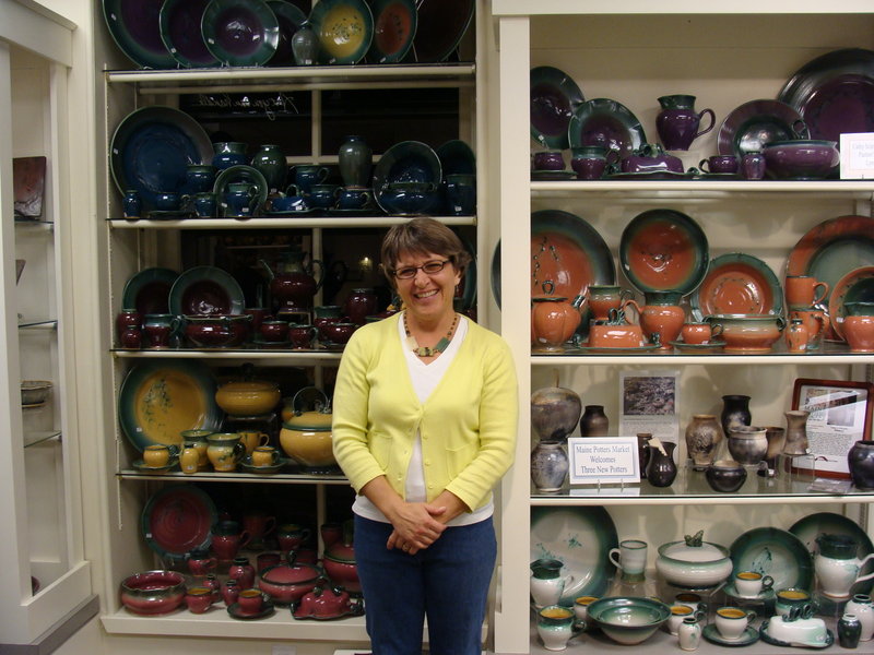 Cathy Schroeder Hammond of Lyman, a potter at the Maine Potters Market in Portland's Old Port, stands in front of her work displayed at the store.