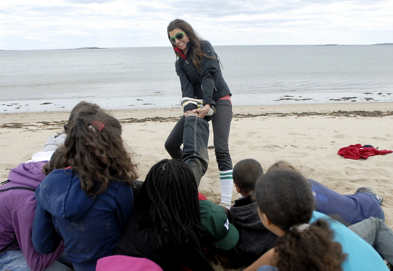 Naturalist Jinx Bauer pulls a student out of a circle to show the effect a wave can have on sea critters.
