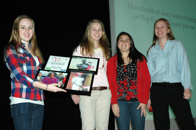 A Flip Flop Challenge to collect and donate 300 pairs of flip-flop sandals for people in the Dominican Republic was held at Thornton Academy Middle School. Grade 7 student Meghan Goebe of Arundel, left, accepts an award on behalf of the student body. The award was presented by TA sophomore Elizabeth Gilboy, second from right, and Cheverus High School students Alison Saunders, second from left, and Katie Saunders, right. The girls delivered the flip-flops to Dominican Republic residents during a mission trip to that country hosted by Sacos United Baptist Church.