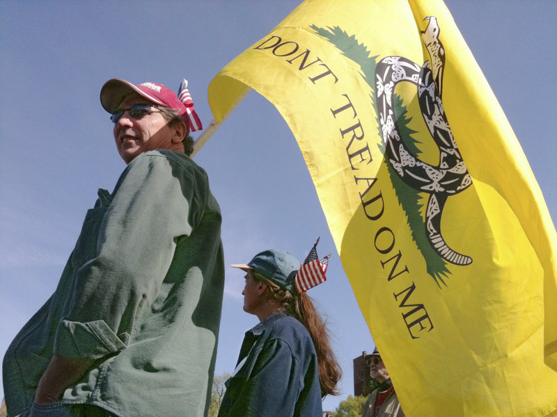 Tom and Debbie Barry of Lisbon Falls hold a Gadsden flag emblazoned with the words "Don't Tread on Me" at the start of the rally in Boston on Wednesday.