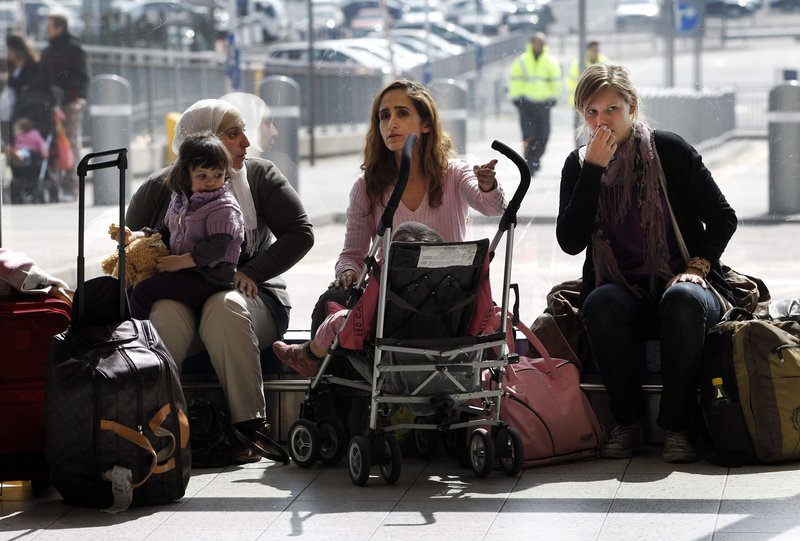 Passengers wait in the departure area at Luton Airport in Luton, England, Thursday as authorities closed air spaces over Britain, Ireland and the Nordic countries.