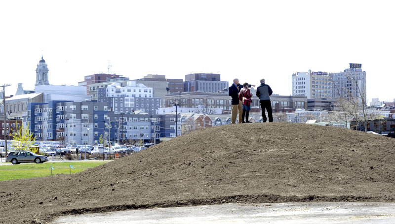 Jim Gooch, Nan Cumming and Mark McAuliffe stand on a berm along a section of the new Bayside Trail, with its great view of the Portland skyline.