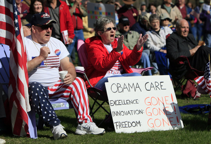 Tea party supporters cheer during a rally Thursday at Capitol Park in Augusta, Maine. The protest featured one person dressed in colonial-era clothing and signs expressing disatisfaction with government, including a warning that “Revolution is brewing.”