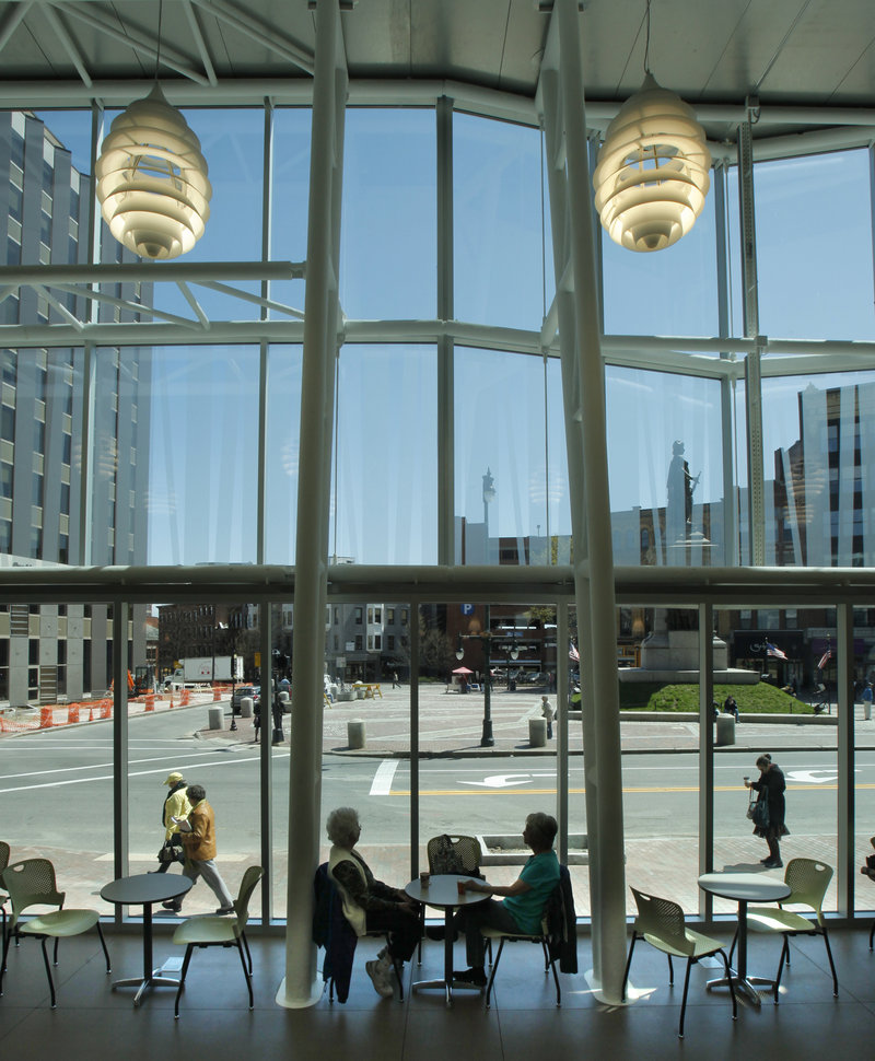 A towering glass facade overlooks Monument Square.
