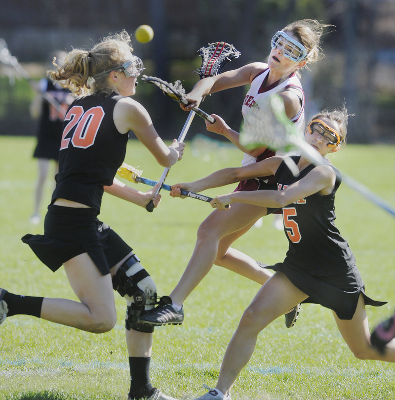 Shelby Colvin of Freeport looks for room between Lilly Wellenbach, left, and Hannah Twombly of North Yarmouth Academy to get off a shot. NYA won the girls’ lacrosse opener on the road, 11-4.