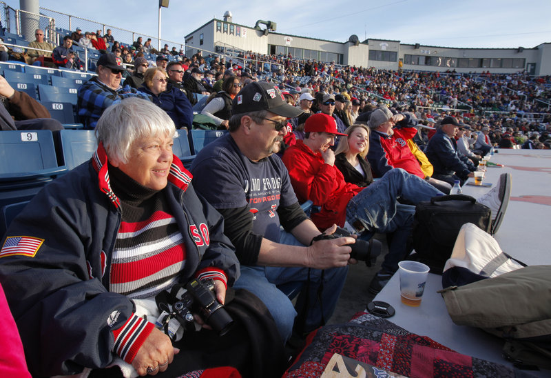 Jackie Mitchell, left, watches the first inning of the Sea Dogs’ home opener Thursday against the Trenton Thunder. Mitchell occupies what she calls the “best seat in the house,” right behind the dugout. The Sea Dogs lost in extra innings, 4-2.
