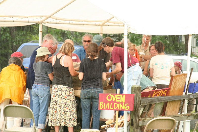 Last year’s rain fails to deter participants in an oven-building workshop. This year, there will be two wood-fired oven workshops – one for clay ovens and one for brick ovens.