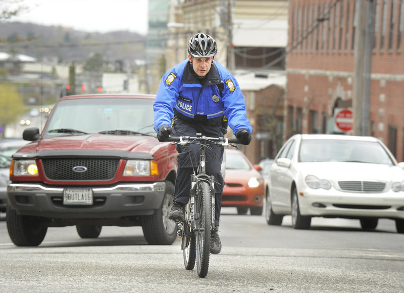 Officer Dan Knight climbs the hill on Preble Street in Portland while patrolling the neighborhood on his bike. Community policing in the city continues to evolve as senior lead officers, such as Knight, are being freed up to focus more on community issues.