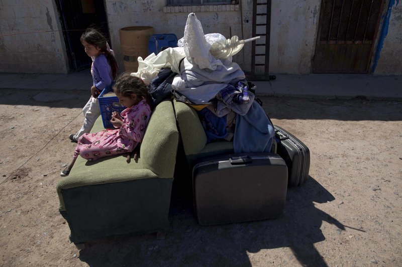Estefania and Liliana, left, sit on their family’s belongings after arriving at their new house in Valle de Juarez, on the outskirts of Ciudad Juarez in northern Mexico. The family left their home in Guadalupe after drug cartel members threatened local residents.
