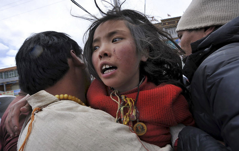 A man carries an earthquake survivor who was rescued Friday after being buried in rubble for more than two days in Yushu county, Qinghai province, western China.