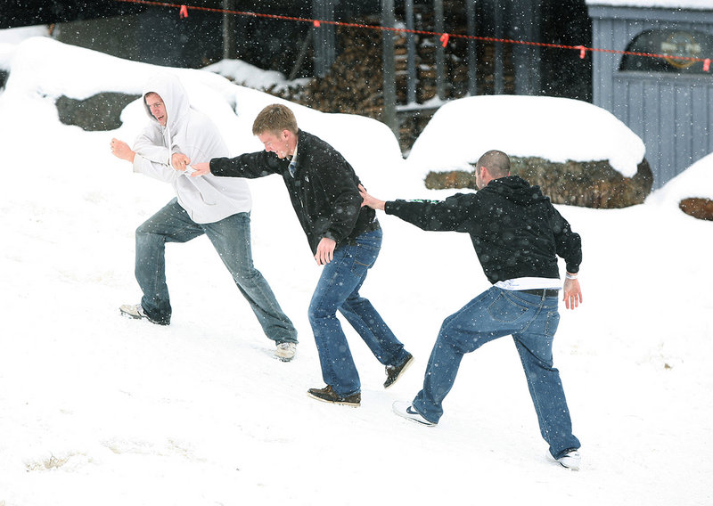 D.J. Gerrish of Rumford, middle, whose old boat shoes have slippery soles, gets a little help making it up the hill from his friends Andrew Dean of Gorham, left, and Ryan Dipompo of Jay as they make their way to the beer and food tent.