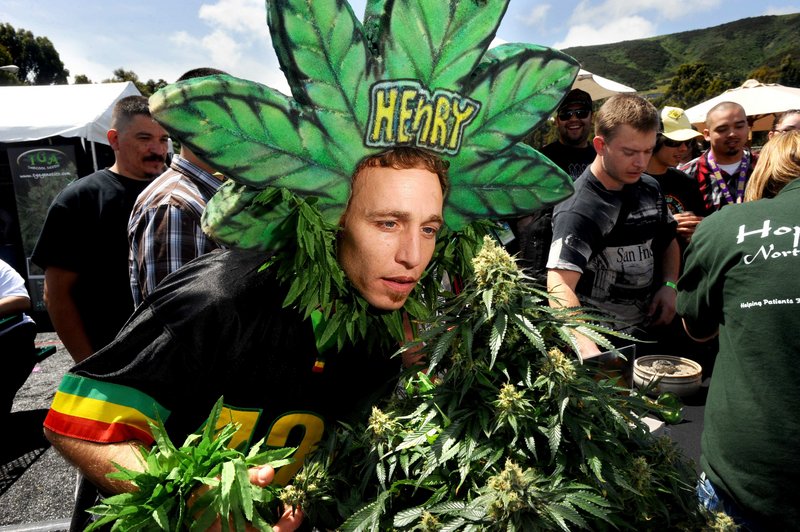 Magic Ellingson, known as Henry Hemp, smells a pot plant at the International Cannabis & Hemp Expo Saturday in Daly City, Calif. A proposal to legalize pot will be on this falls state ballot.