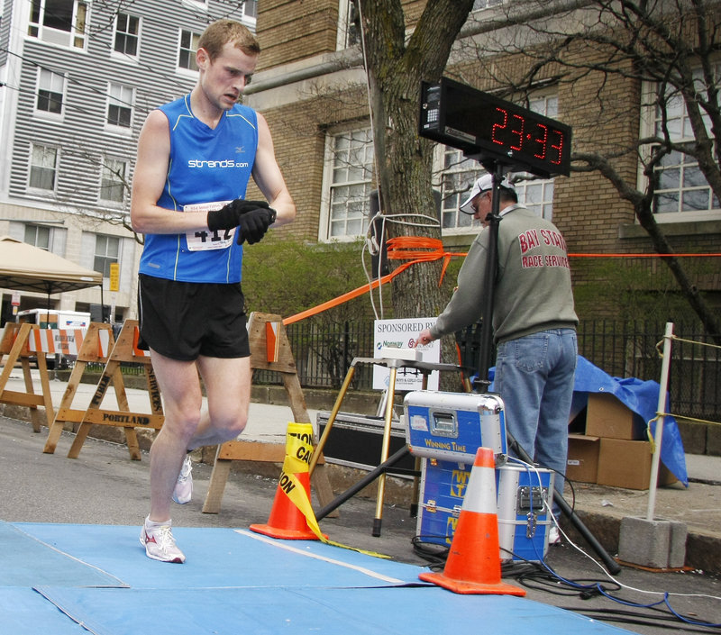 Patrick Tarpy of Yarmouth checks his watch and, yes, his winning time of 23:35 in the Patriots Day 5-miler earned him $1,000 and was just 2 seconds off the course record.