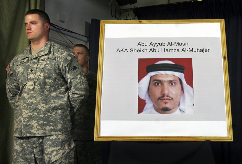 A U.S. soldier stands by a photograph of Abu Ayyub al-Masri, leader of al-Qaida in Iraq, at a news conference in June 2006. Iraq’s prime minister said Monday that two of the most wanted al-Qaida in Iraq figures were killed in a joint operation with the United States.