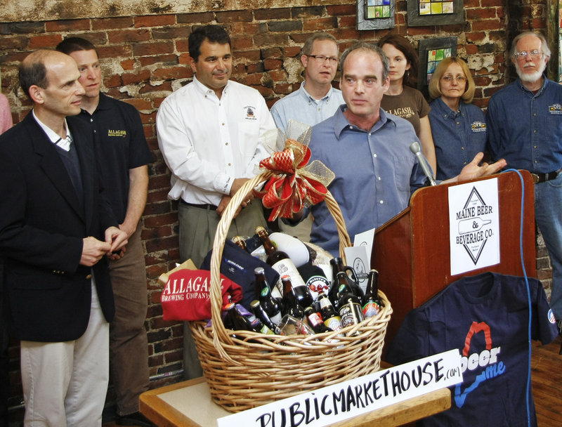 Maine Beer and Beverage Corp. owner Bill Milliken speaks about the shipment of assorted Maine brews, along with other Maine products from the Public Market House, as Gov. John Baldacci listens at left, before sending it off to President Obama on Monday.