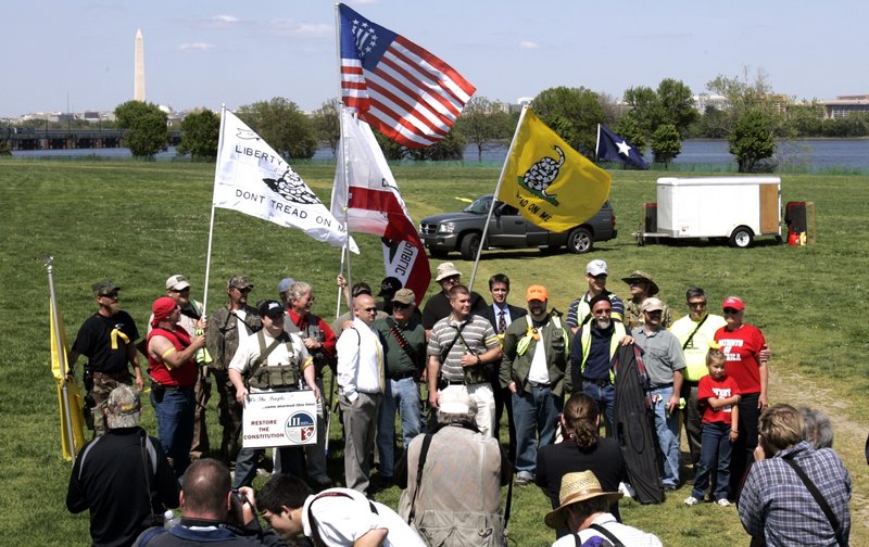 Armed protesters gather for a group photo after holding a rally for First and Second Amendment rights at a “Restore the Constitution” rally at Gravelly Point Park in Arlington, Va., on Monday. Like-minded but unarmed demonstrators also rallied in the nation’s capital.