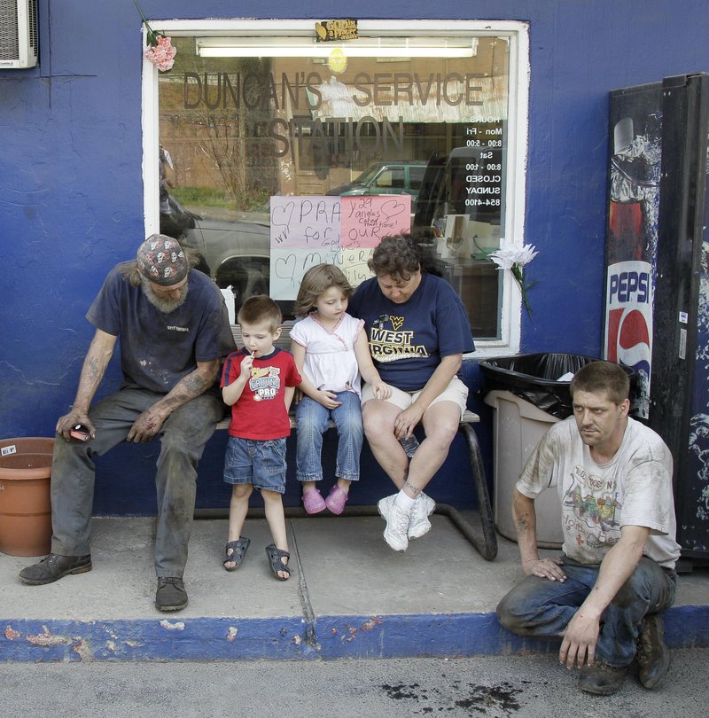 From left, Jerry Bearfield, Jaden Clemons, 3, his sister Gabrielle, 4, their grandmother Gladys Clemons and Jerry’s brother Randy Bearfield gather in Whitesville, W.Va., April 12 for a national moment of silence for the 29 miners who died in the explosion at Massey Energy Co.’s Upper Big Branch mine in Montcoal, W.Va., on April 5. Critics say the industry is full of former government officials, leading to federal regulations that benefit the companies at the expense of worker safety.