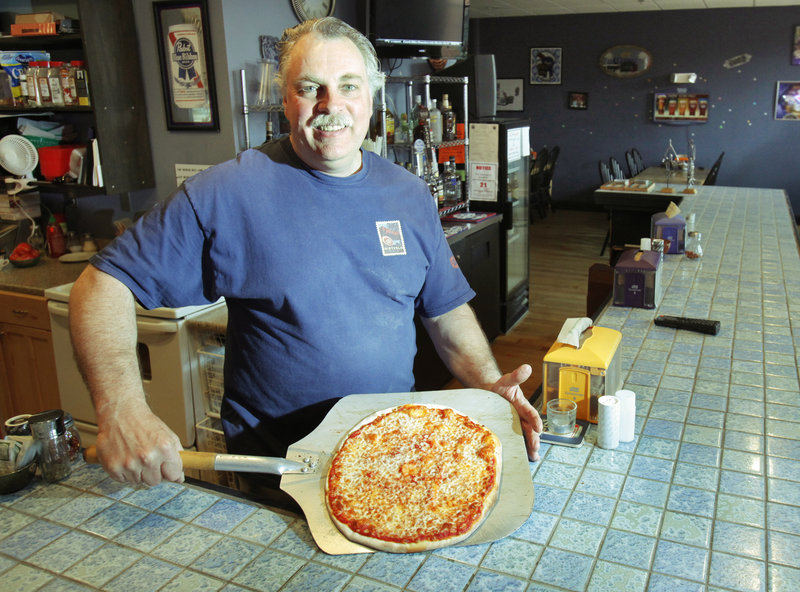 Jack Fowler prepares to serve a cheese pizza at Union House Pub and Pizza at the North Dam Mill in Biddeford.