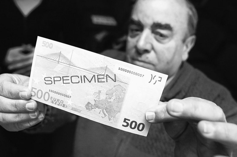 Walter Muscat of Attard, Malta, inspects a specimen 500-euro note in 2007. A report by the Bank of Italy says the high-value bill “simplifies the logistical management of large sums of money,” making it a favorite of criminals.