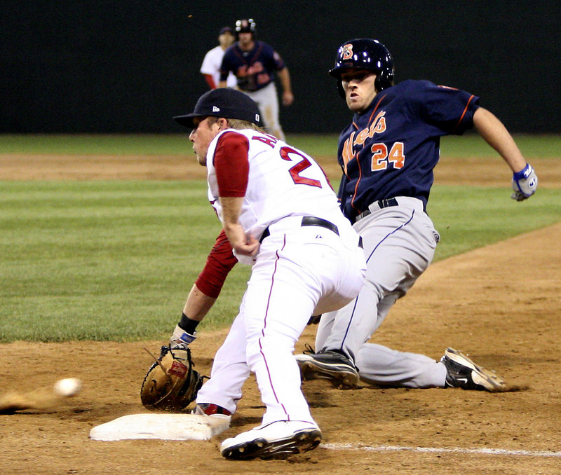 Portland pitcher Ryne Lawson tags out D.J. Wabick of the Binghamton Mets, who was attempting to score Tuesday night on a pitch that got away. Umpire Tom Honec prepares to make the call. Binghamton won, 15-3.