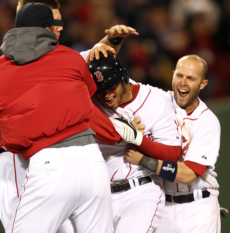 Darnell McDonald is mobbed by teammates, including Dustin Pedroia, right, after his RBI single completed Boston’s comeback in a 7-6 victory over Texas on Tuesday night.
