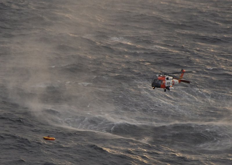 The crew of a Coast Guard helicopter prepares to rescue one of the four crew members from the Northern Belle in the Gulf of Alaska. The fishing vessel was hit by a swell and tipped on its side Tuesday night before sinking.