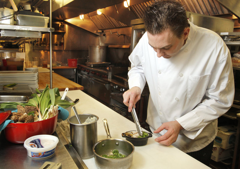 Jeffrey Savage, executive chef at On the Marsh Bistro in Kennebunk, arranges fiddleheads in his Spring Peekytoe Crab Bake appetizer.