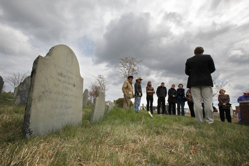 Poets and others gather as Freeport poet Simon Skold reads “Fog Talk,” a poem by Phillip Booth, at the Eastern Cemetery in Portland on Friday. Prominent poets from throughout Maine read poetry at the cemetery to announce Dead Poets Remembrance Day.