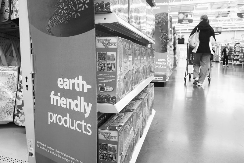 A Walmart customer walks past a line of earth friendly products.