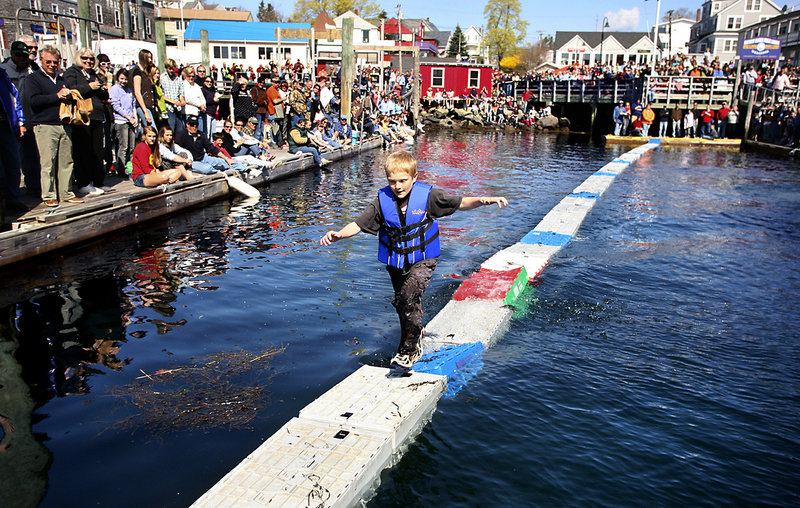 Nolin Conlin runs across crates filled with seaweed during the lobster crate-running competition. The competitors ran back and forth across the crates as fast as they could for three minutes without falling. Conlin finished second in the competition by running across 240 crates.