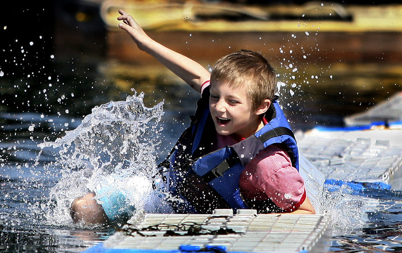 Chris Hamlet, 7, falls into the water after making it across 17 crates during the lobster crate-running competition at the Fishermen's Festival in Boothbay Harbor on Saturday. Competitors demonstrated their agility by running across 40 crates tied to a dock and a boat.