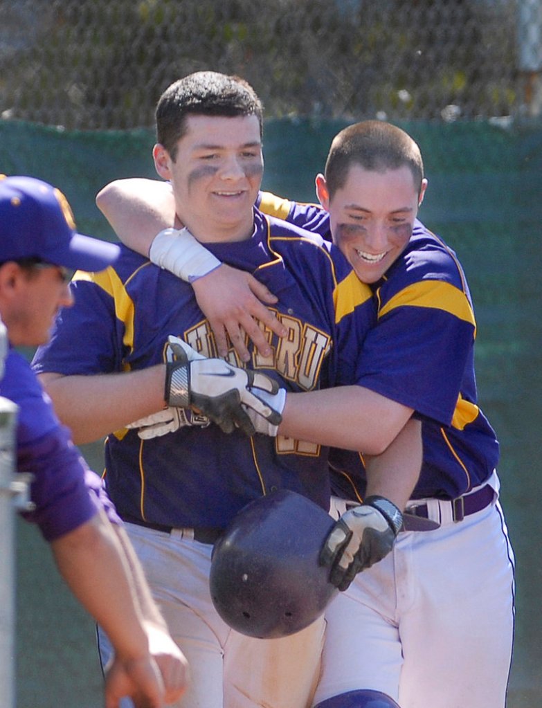Peter Potthoff of Cheverus, left, is welcomed by teammate Nic Lops after scoring the winning run on a passed ball in the seventh Saturday, producing a 5-4 victory that ended Deerings 50-game winning streak.