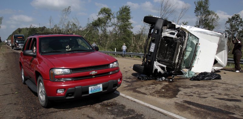 The Associated Press A motorist drives past an overturned truck which was among several vehicles damaged when a tornado crossed Interstate Highway 55 south of Durant, Miss., on Saturday.