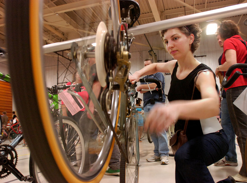 Rafaela Huonder of Portland checks out a road bike selling for $20 as the Greater Portland Bicycle Coalition held its annual bike swap Sunday in Sullivan Gymnasium at the University of Southern Maine in Portland.